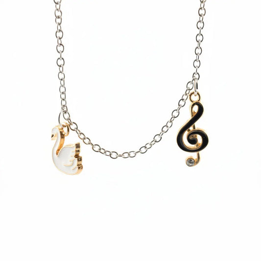 Charm bracelet with a swan charm and a black treble clef charm on a fine chain