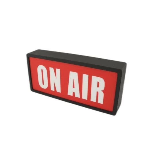Black On Air LED light box with white lettering on a red faceplate, lit on a home studio desk